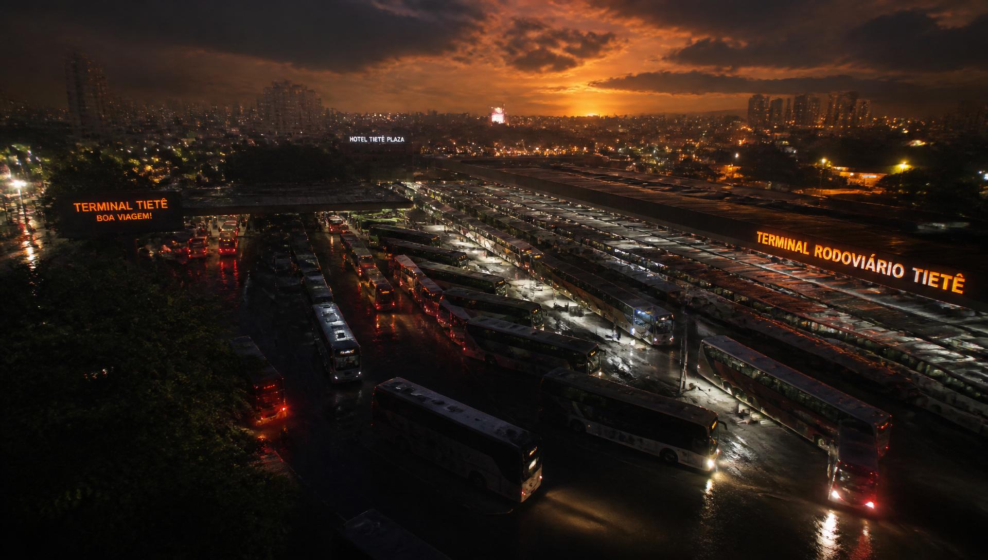 Terminal rodoviário ao entardecer com dezenas de ônibus
